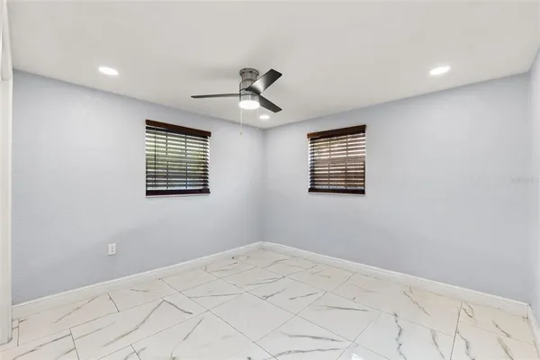 a view of an empty room with a floor to ceiling window next to yard and a lake