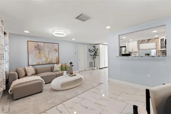 a living room with furniture and kitchen view