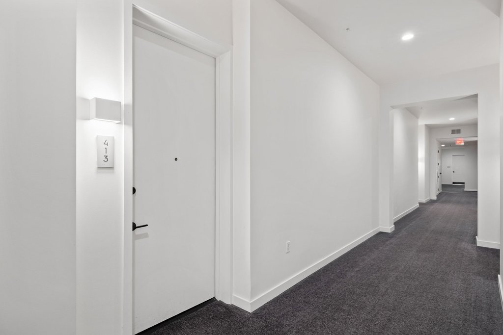 800 Embassy Drive, Unit 413 Austin, TX 78702 - Photo 18 of 27 Hall with recessed lighting and dark carpet