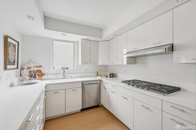 a kitchen with cabinets appliances a sink and a window