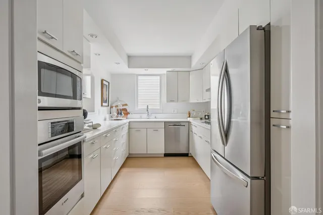 a kitchen with a refrigerator sink and stove top oven