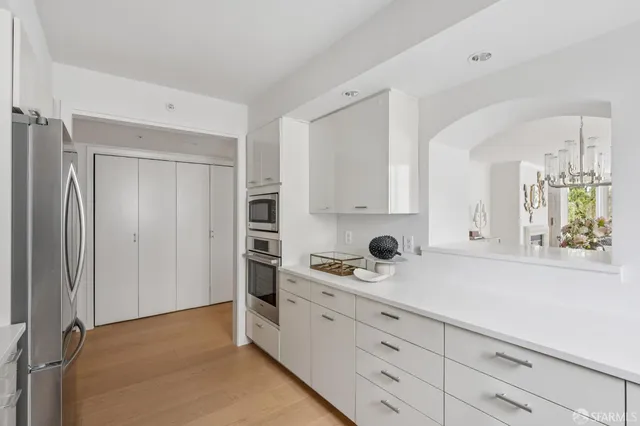 a kitchen with white cabinets and window