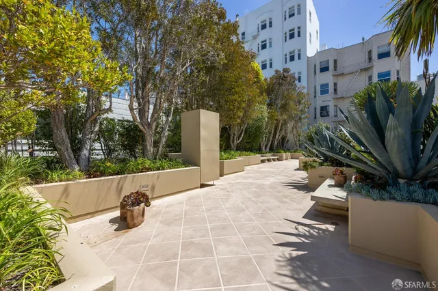 a view of roof deck with couches and wooden fence