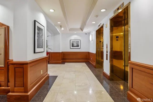 a front view of a building with lot of cars and trees