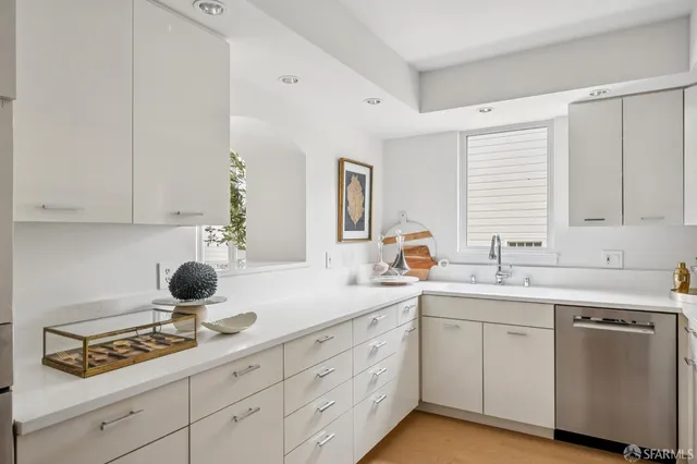 a kitchen with a sink dishwasher stove and cabinets