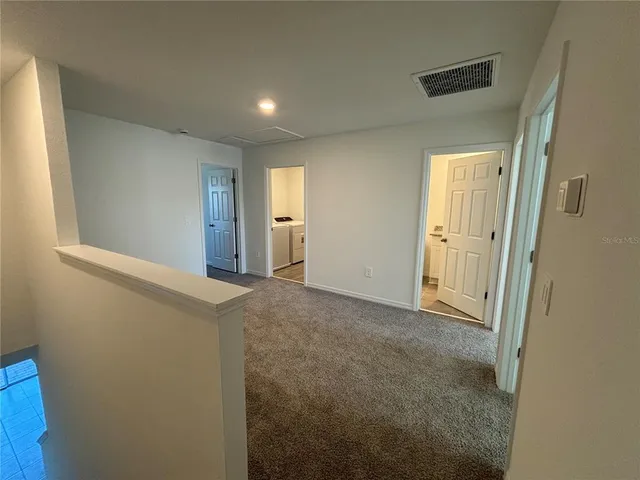 a view of hallway with a bathroom