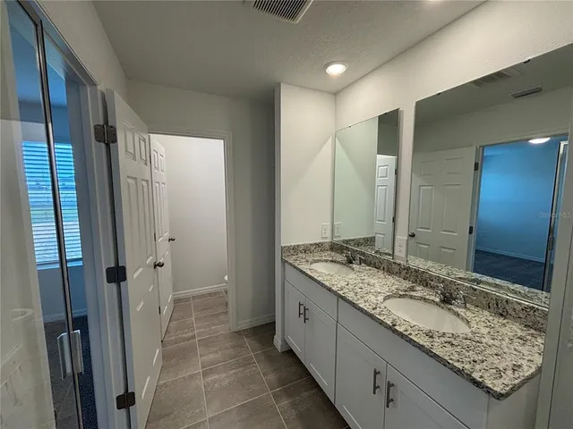 a bathroom with a granite countertop sink and toilet