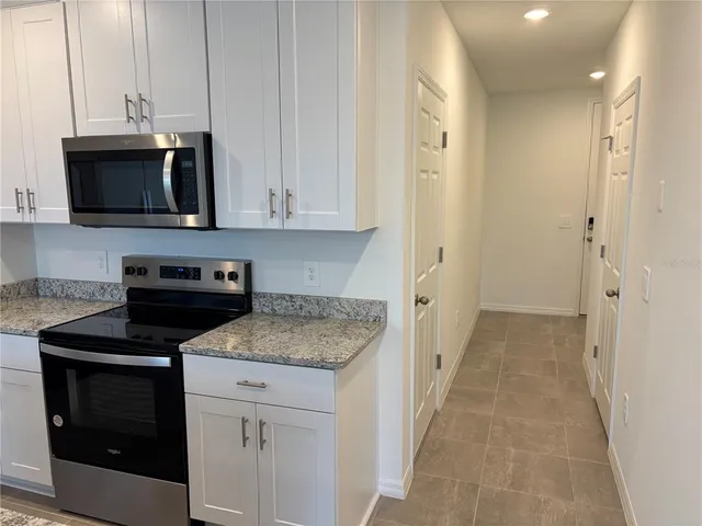 a kitchen with stainless steel appliances granite countertop a stove a microwave and a refrigerator