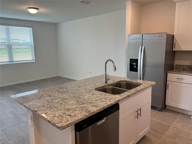 a kitchen with stainless steel appliances granite countertop a sink dishwasher and stove