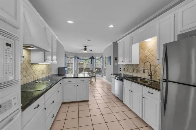 a large kitchen with a stove a sink dishwasher a refrigerator and cabinets