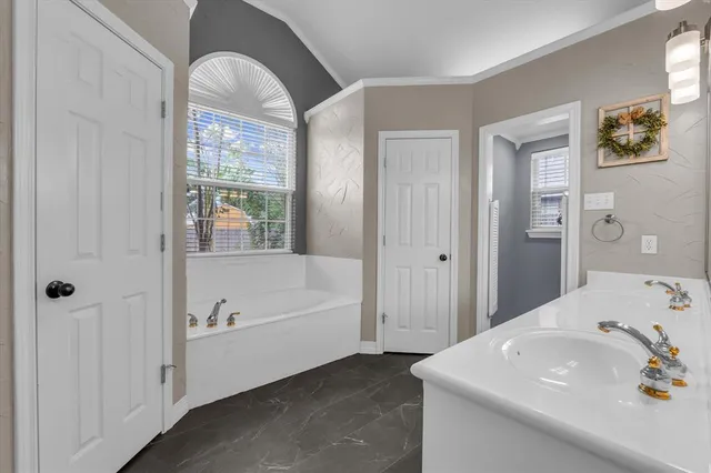 a spacious bathroom with a double vanity sink a large mirror a shower and a