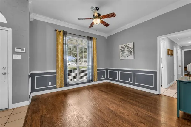 a view of an empty room with a window and wooden floor