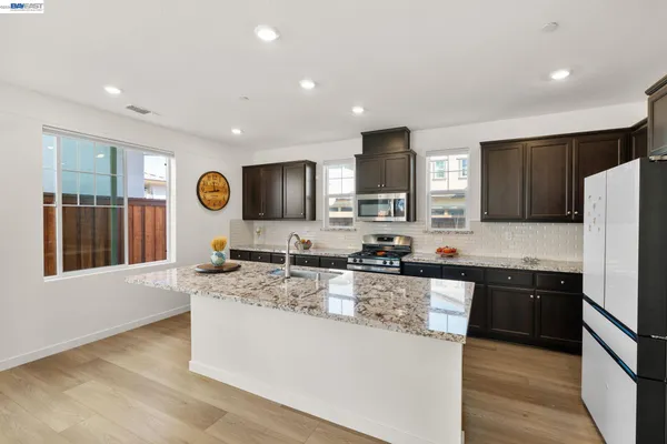 a kitchen with stainless steel appliances granite countertop a sink stove and refrigerator