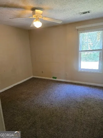 an empty room with a window and a ceiling fan