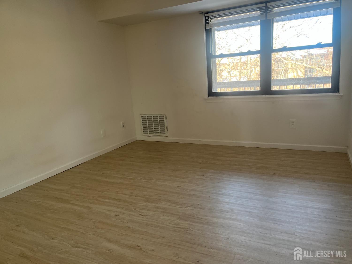 1947 Raspberry Court Edison, NJ 08817 - Photo 12 of 14 an empty room with wooden floor and windows