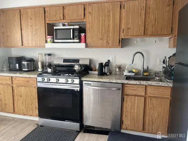 a kitchen with stainless steel appliances granite countertop a stove a microwave and cabinets