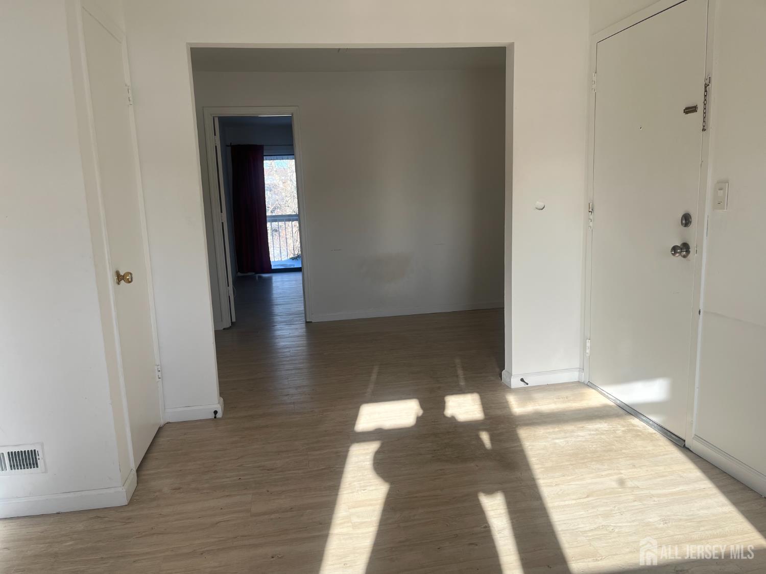 1947 Raspberry Court Edison, NJ 08817 - Photo 10 of 14 a view of a hallway with wooden floor and glass door
