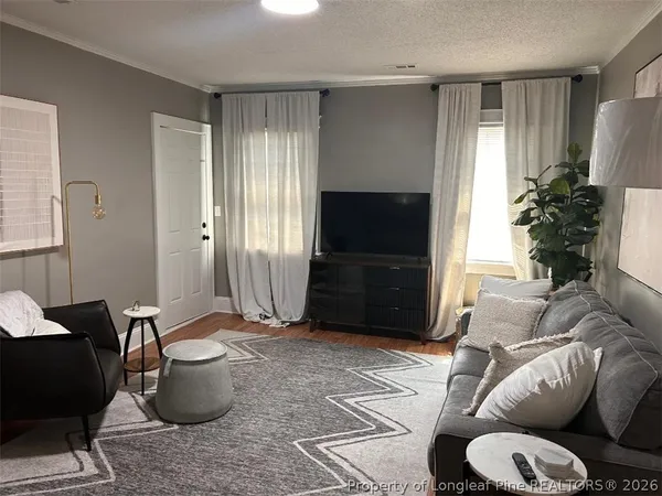 a living room with furniture a flat screen tv and a window