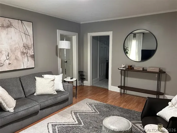 a living room with furniture a mirror and a lamp