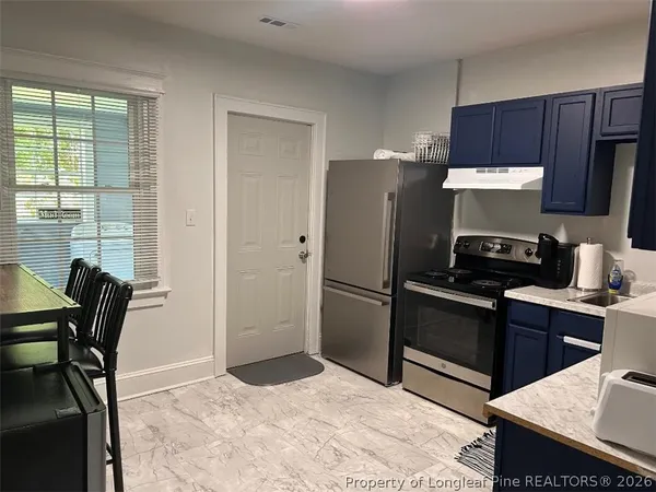 a kitchen with granite countertop a refrigerator stove and microwave