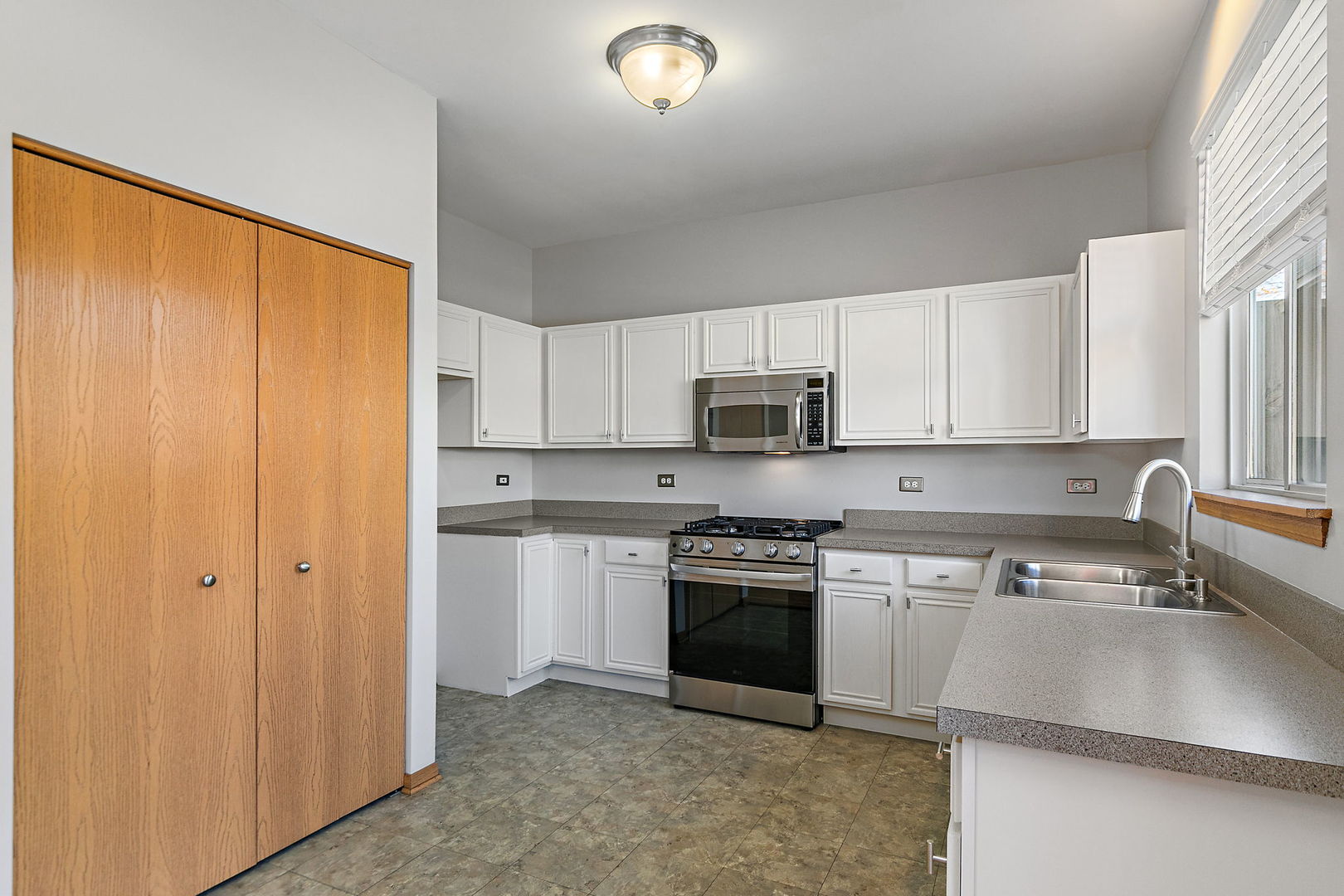 614 Littleton Trail Elgin, IL 60120 - Photo 13 of 30 a kitchen with stainless steel appliances granite countertop a stove a sink and white cabinets