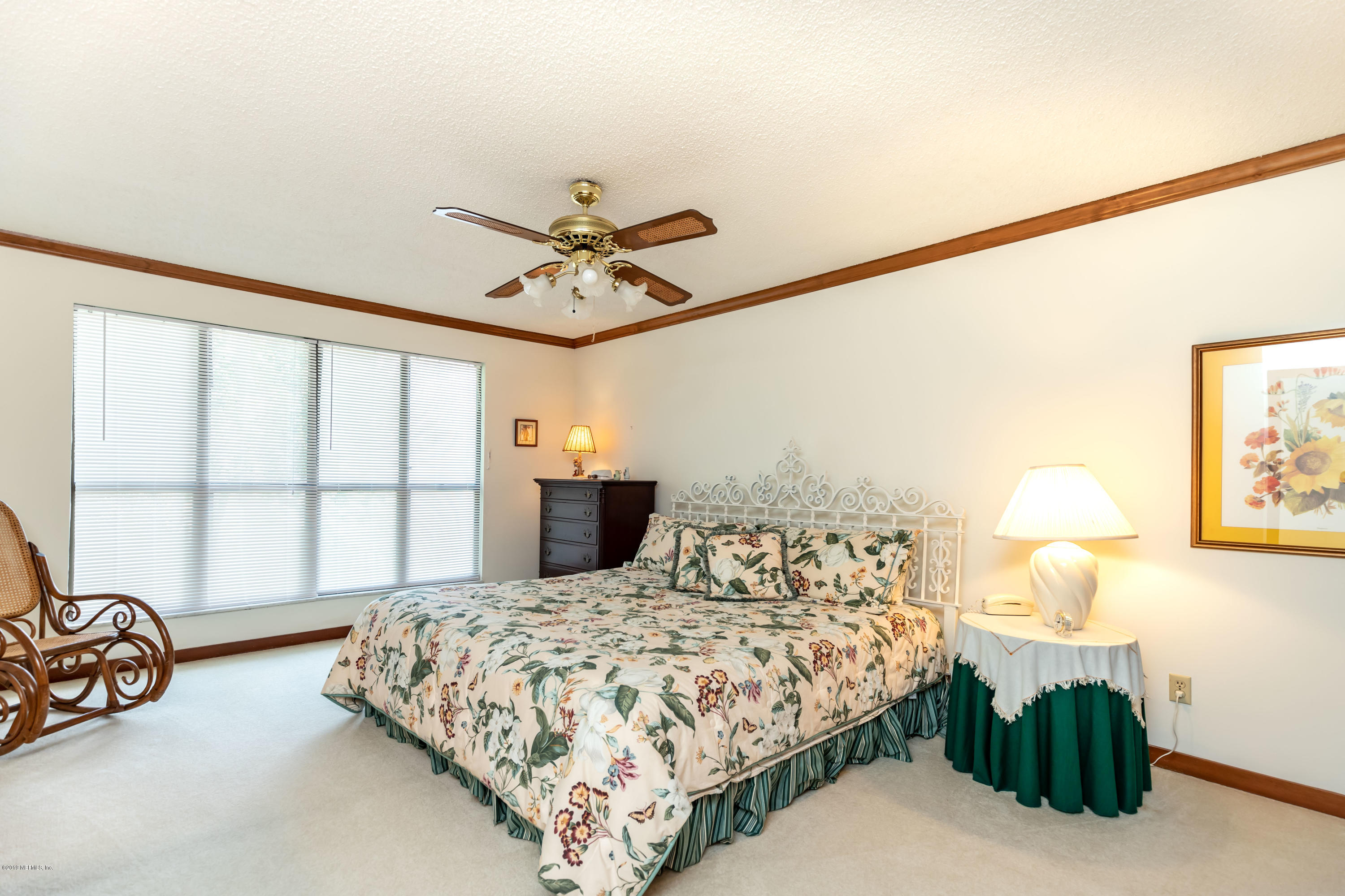 2911 Front Road Jacksonville, FL 32257 - Photo 48 of 71 a bedroom with a large bed and a chandelier