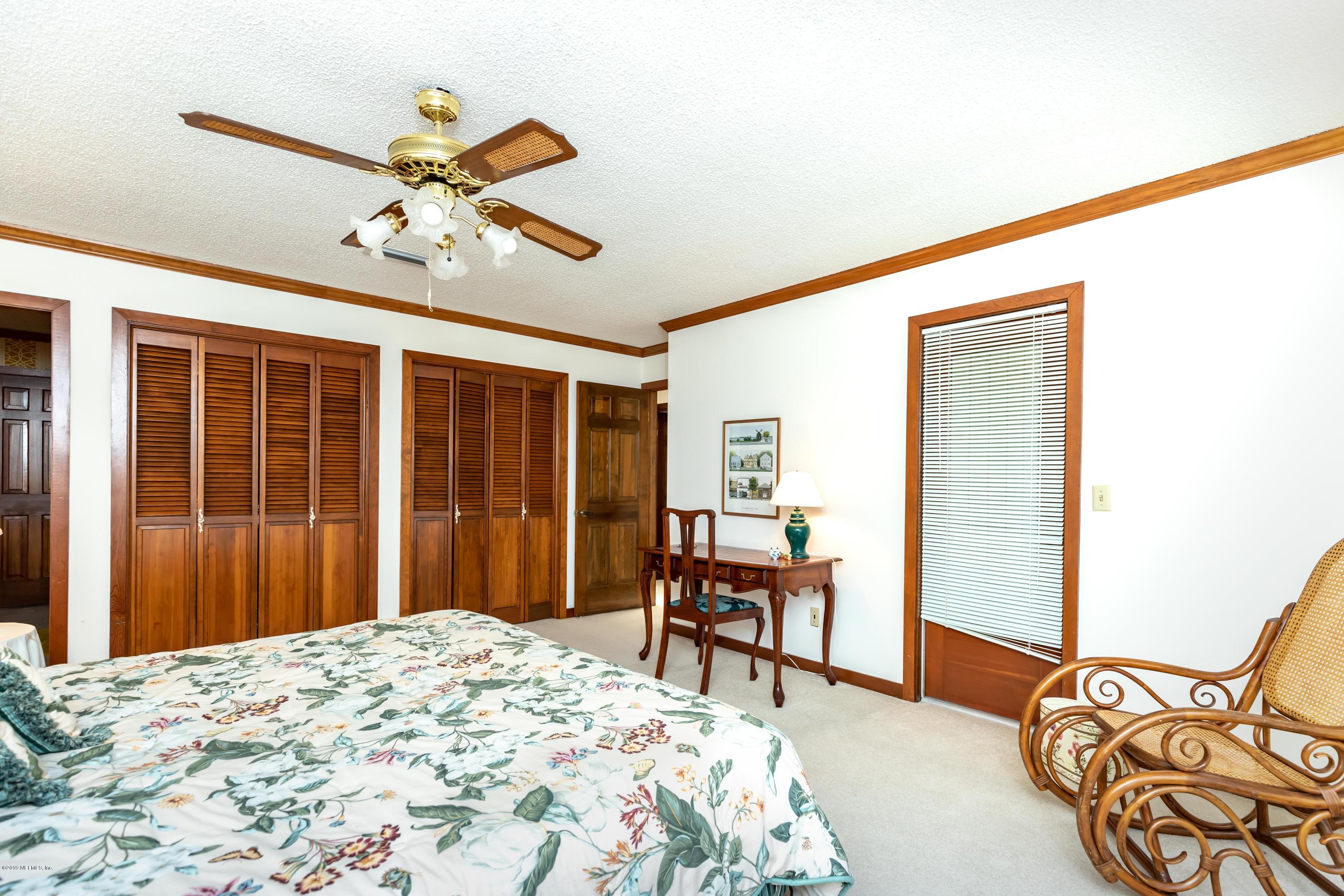 2911 Front Road Jacksonville, FL 32257 - Photo 49 of 71 a bedroom with a bed and a chandelier