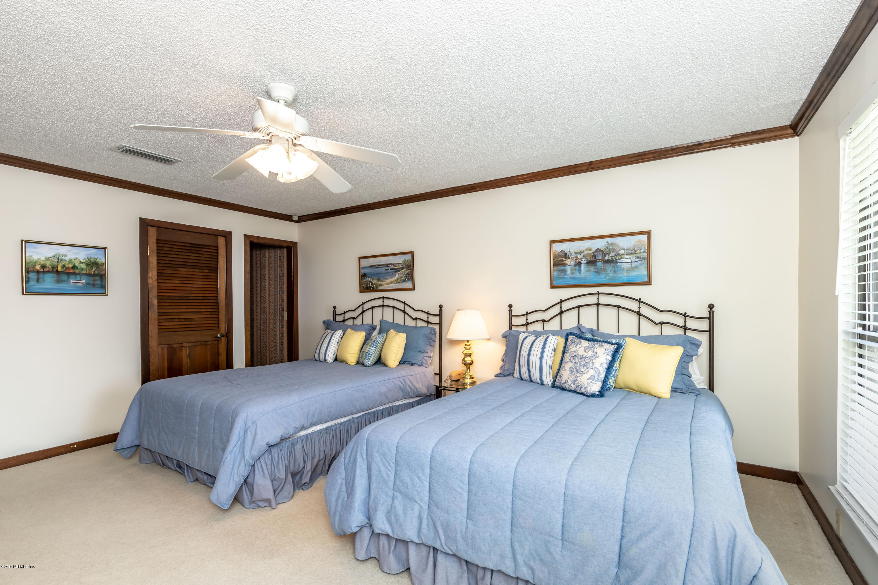 2911 Front Road Jacksonville, FL 32257 - Photo 61 of 71 a bedroom with a large bed and a chandelier