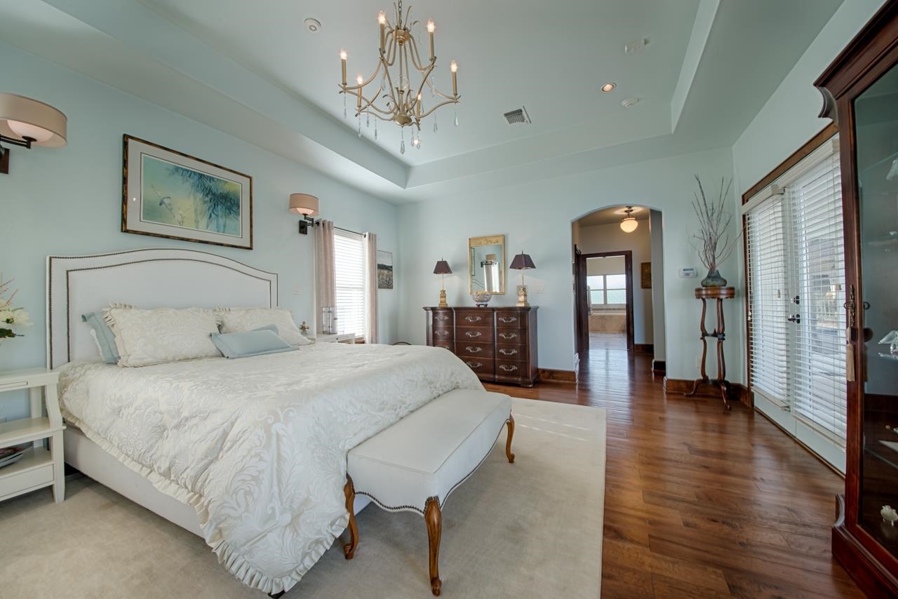 1600 Legends Parkway Kingsland, TX 78639 - Photo 12 of 30 a bedroom with a large bed and a chandelier