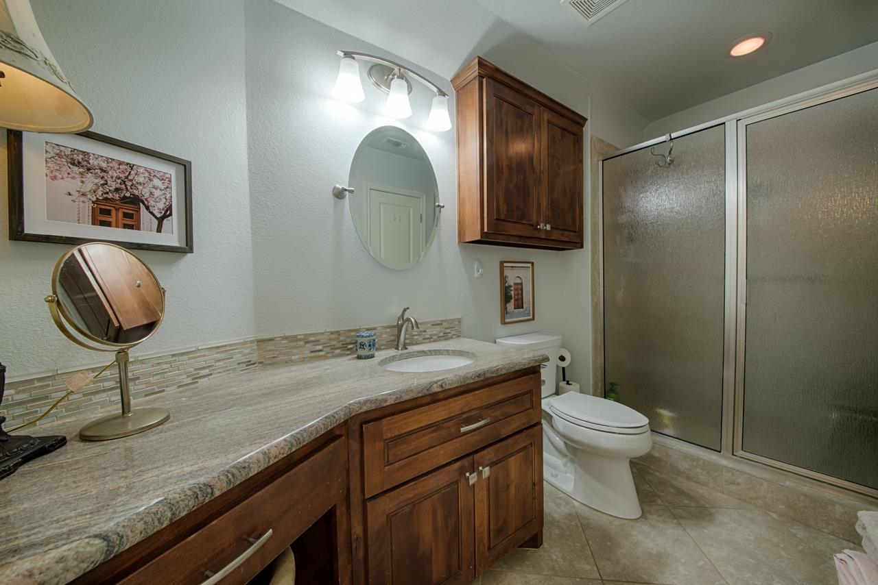 1600 Legends Parkway Kingsland, TX 78639 - Photo 22 of 30 a bathroom with a granite countertop toilet sink and mirror