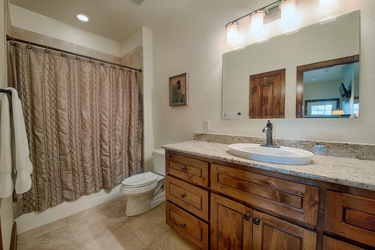 1600 Legends Parkway Kingsland, TX 78639 - Photo 25 of 30 a bathroom with a granite countertop sink a toilet and a mirror