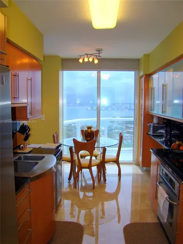 a dining room with furniture and a floor to ceiling window