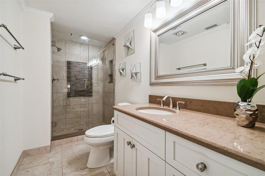 36750 Highway 19, Unit 23213 Palm Harbor, FL 34684 - Photo 32 of 73 a bathroom with a granite countertop sink a toilet and shower