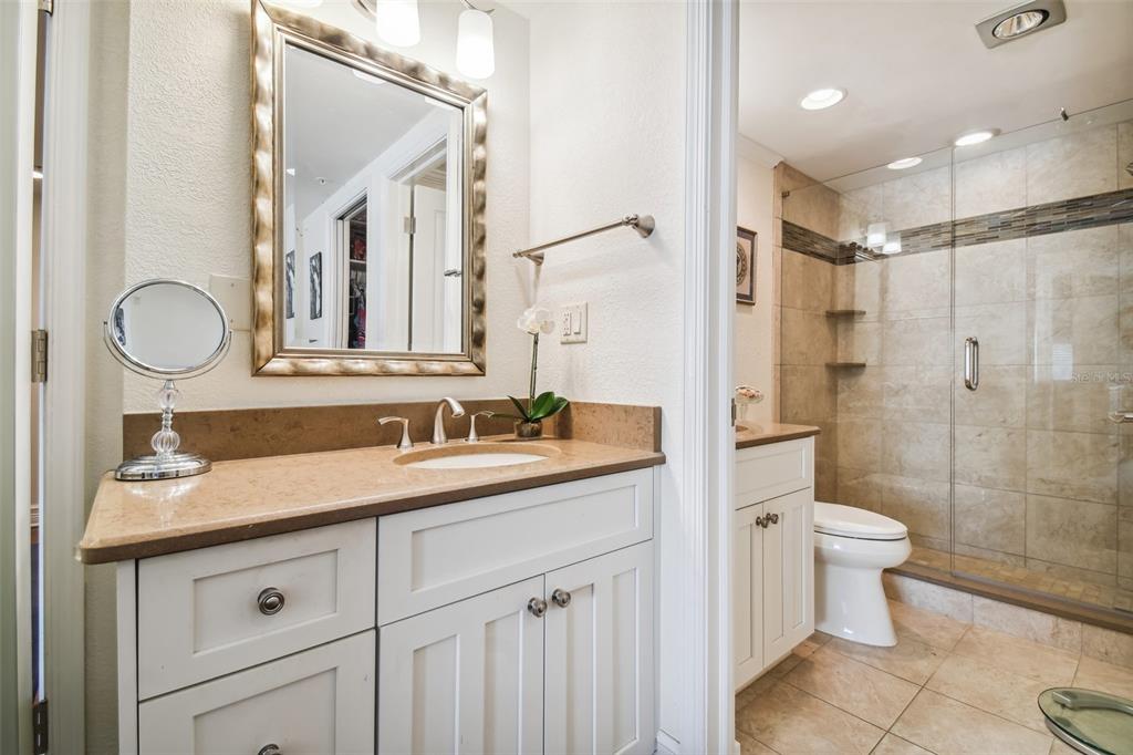 36750 Highway 19, Unit 23213 Palm Harbor, FL 34684 - Photo 41 of 73 a bathroom with a granite countertop sink a toilet a mirror and shower