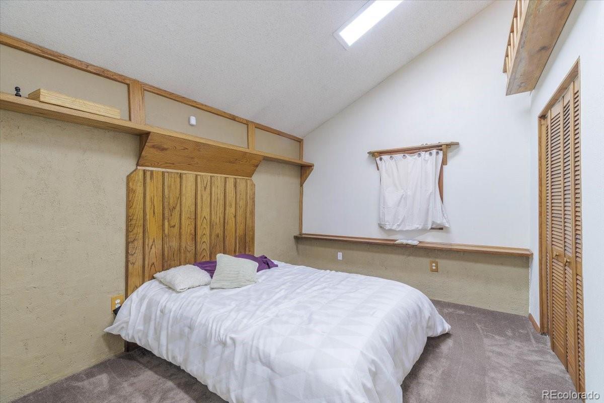 2283 Haskell Way Watkins, CO 80137 - Photo 11 of 36 a bedroom with a bed and a chandelier