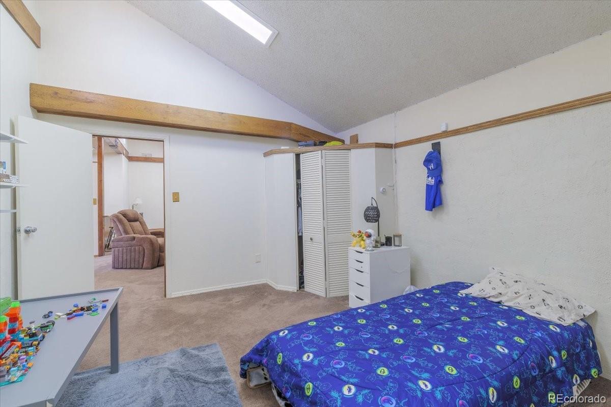 2283 Haskell Way Watkins, CO 80137 - Photo 14 of 36 a bedroom with a bed and a walk in closet