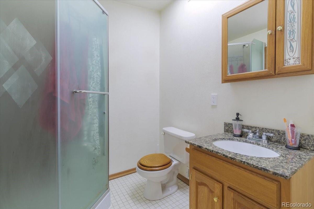 2283 Haskell Way Watkins, CO 80137 - Photo 17 of 36 a bathroom with a granite countertop sink toilet and a mirror