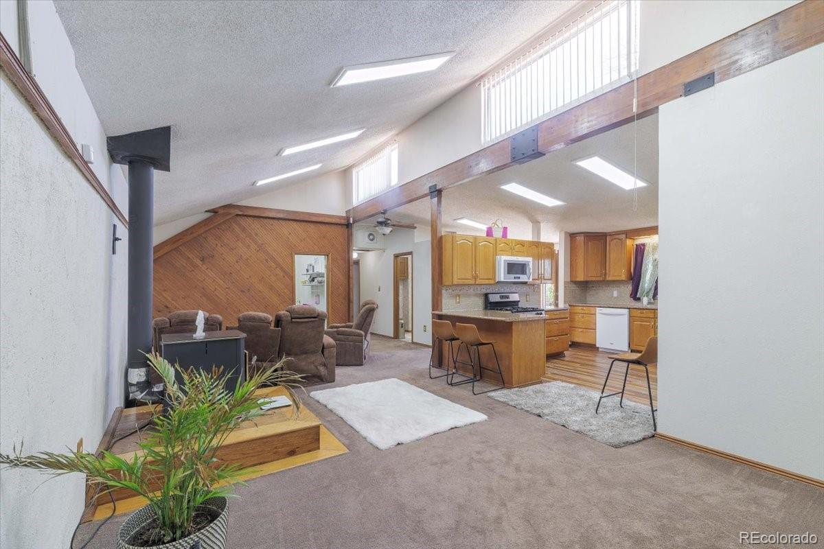 2283 Haskell Way Watkins, CO 80137 - Photo 7 of 36 a living room with furniture a large window with kitchen view