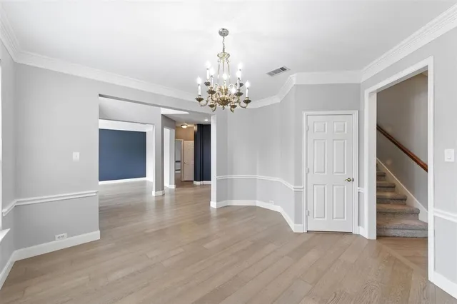 a view of a hallway with wooden floor and a chandelier