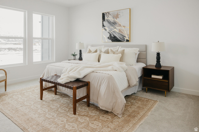 1066n South State Road, Unit ATWOOD Salem, UT 84653 - Photo 22 of 29 Bright bedroom featuring two large windows, carpet flooring, a built-in upholstered headboard, and a wood-finish nightstand