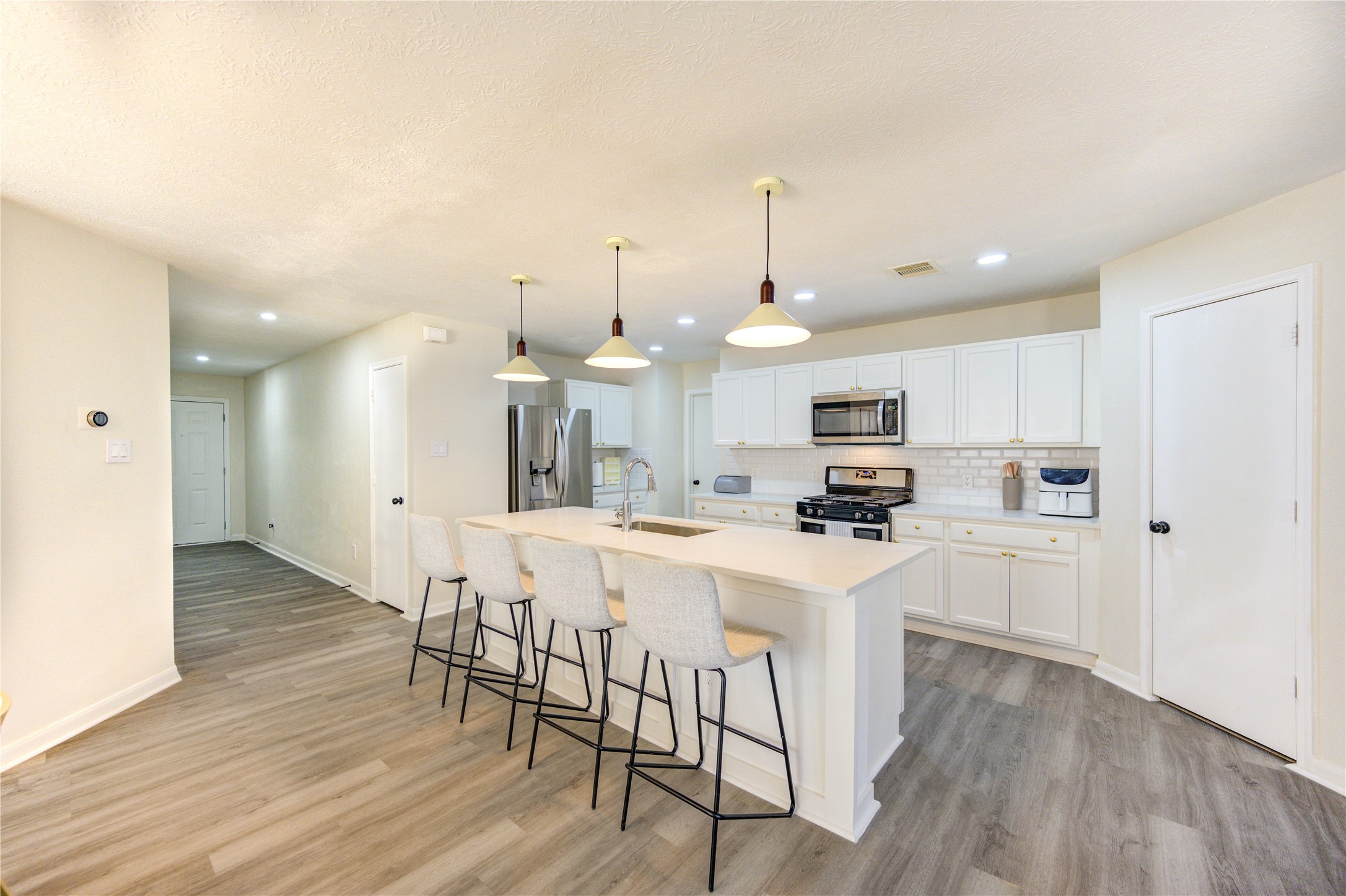 1010 Hummingbird Point Lane Houston, TX 77090 - Photo 11 of 50 a kitchen with stainless steel appliances kitchen island granite countertop a table chairs and a refrigerator