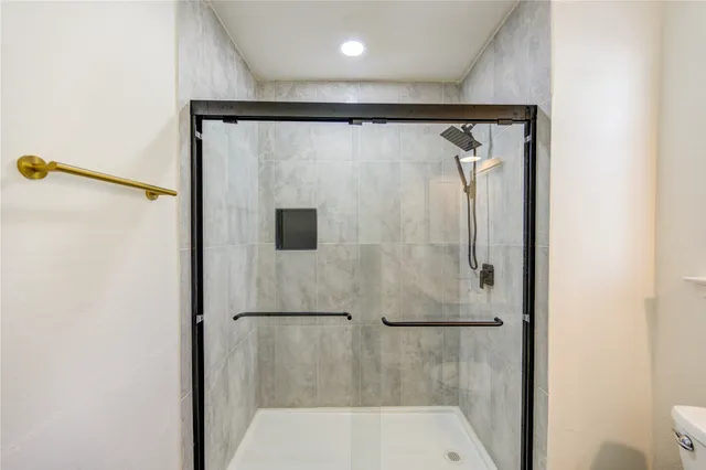 a bathroom with a granite countertop sink toilet and shower