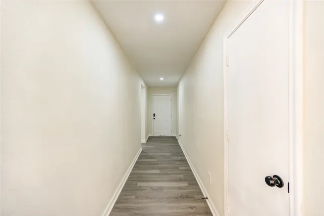 a view of a hallway with wooden floor