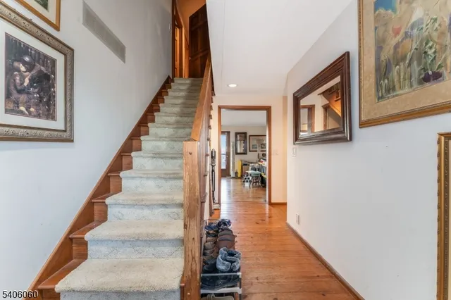 a view of staircase with lots of frames on wall and two windows