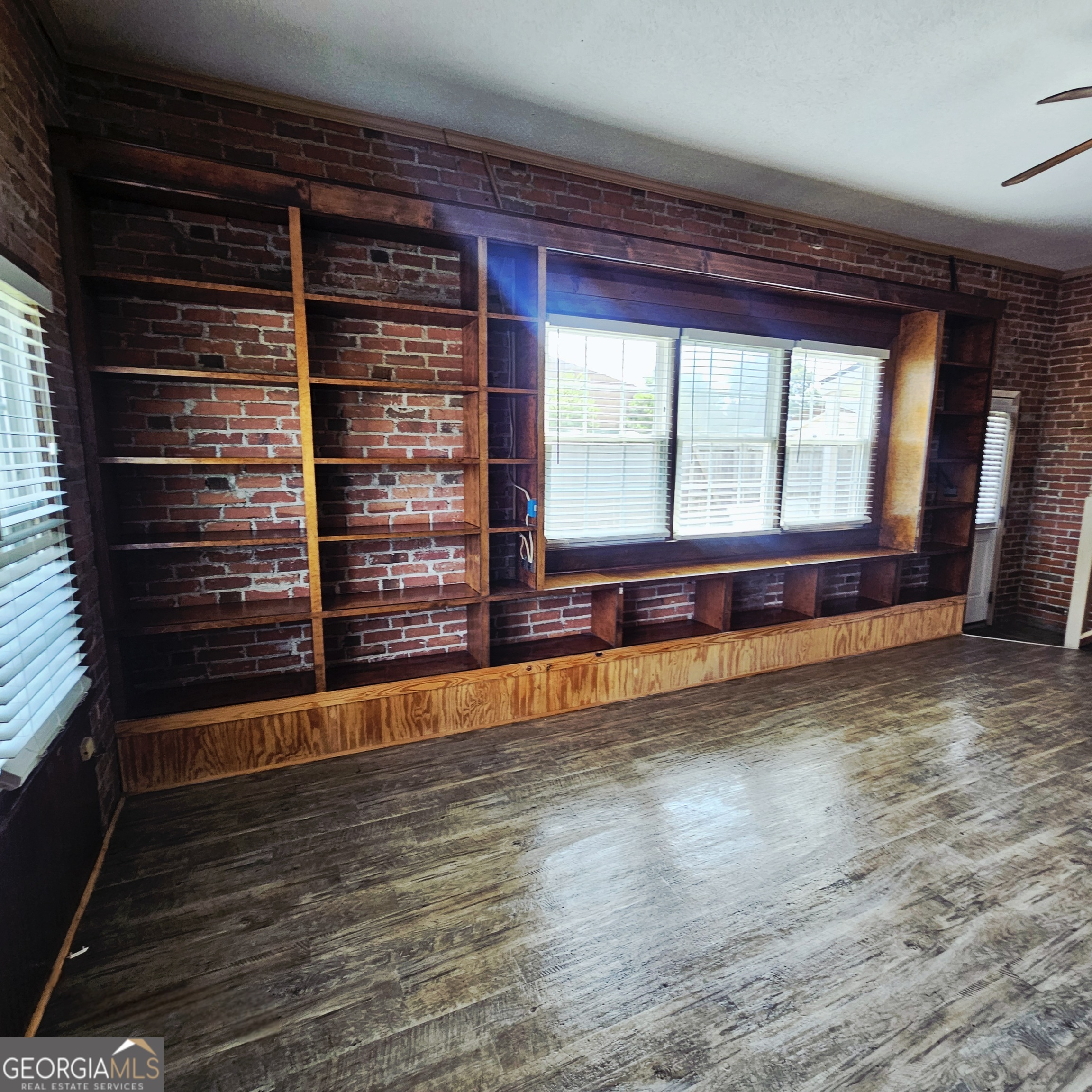 107 East Liberty Street Claxton, GA 30417 - Photo 9 of 29 a view of an empty room with wooden floor and a window