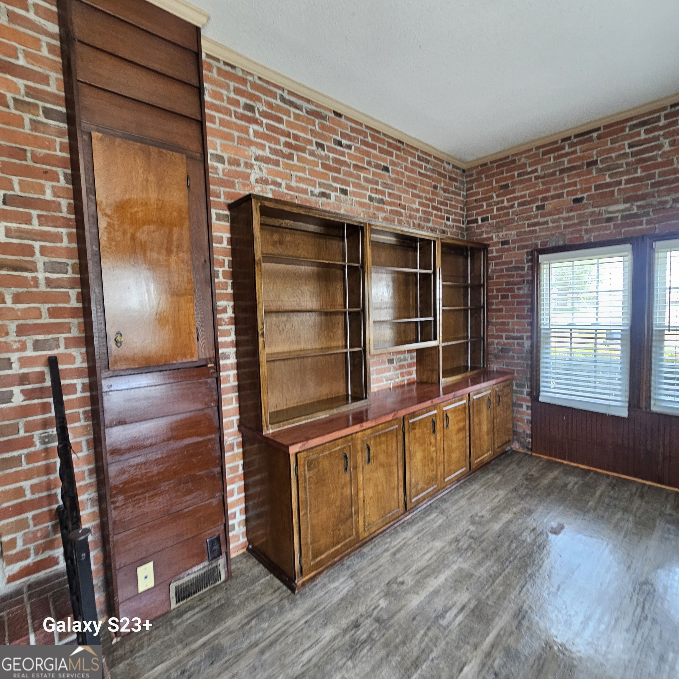 107 East Liberty Street Claxton, GA 30417 - Photo 10 of 29 a view of an empty room with wooden floor and a window