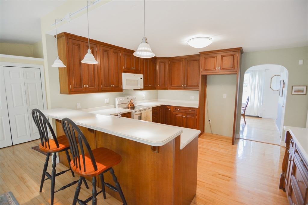 12 Hazen Road Shirley, MA 01464 - Photo 5 of 41 a kitchen with stainless steel appliances granite countertop a sink a microwave refrigerator and chairs