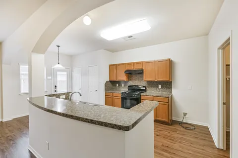 a kitchen with stainless steel appliances granite countertop a sink a stove and a refrigerator