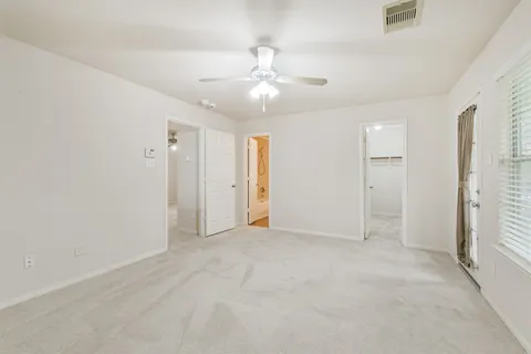 an empty room with closet and a ceiling fan