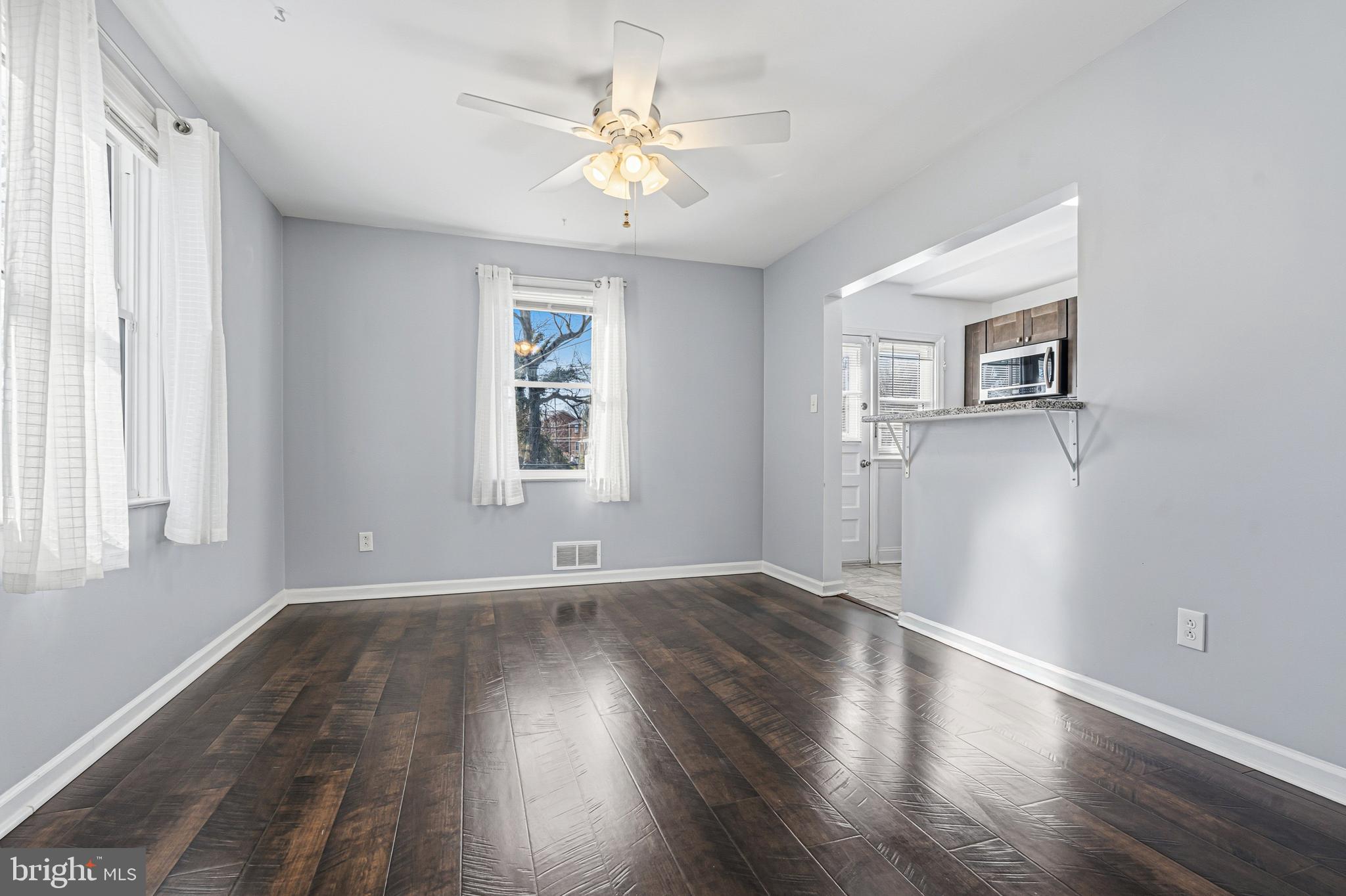 5127 Terrace Drive Nottingham, MD 21236 - Photo 6 of 33 an empty room with wooden floor chandelier fan and windows